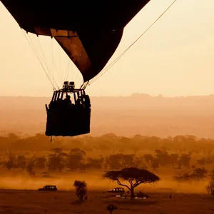 Hot air balloon flying over the plains in Serengeti National Park at sunset