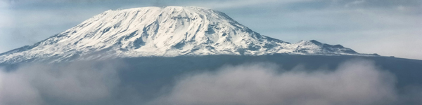 Snow-covered peak of Mount Kilimanjaro above the skies