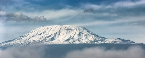 Snow-covered peak of Mount Kilimanjaro in cloudy weather